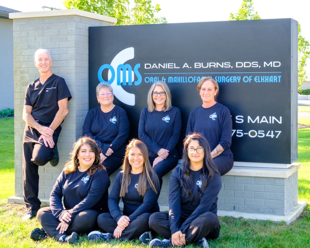 group photo outside sign