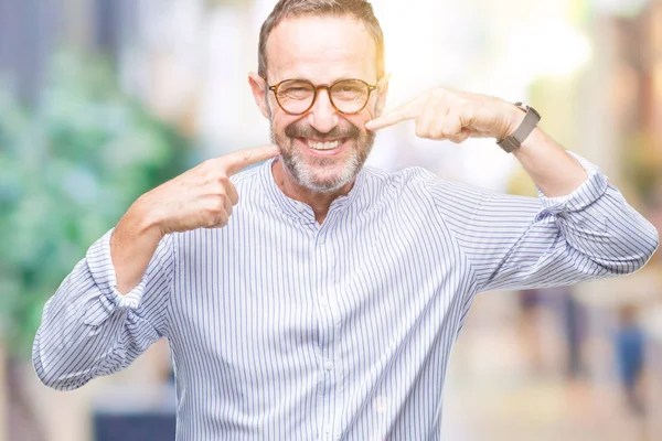 man pointing to his mouth smiling